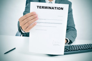 a man in suit in his desk showing a figured signed termination document